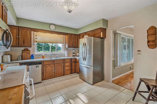 8351 Duffield Rd, Gaines, MI 48436 - kitchen featuring stainless steel appliances, a sink, light countertops, and light tile patterned floors