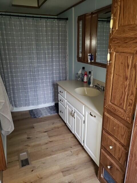 15754 N 10th Ave, Marion, MI 49665 - full bath with wood finished floors, vanity, and curtained shower
