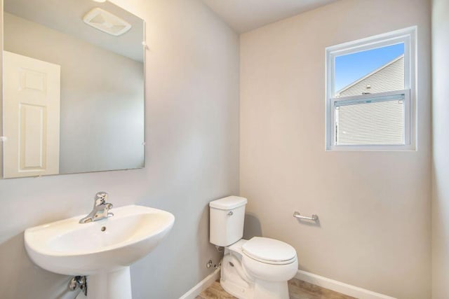 13678 Oasis Ave, Holland, MI 49424 - half bathroom featuring toilet, baseboards, a sink, and wood finished floors