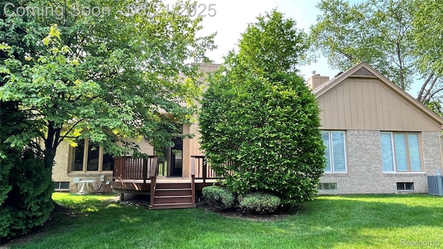 1228 Autumn Dr, Troy, MI 48098 - rear view of house featuring brick siding, a wooden deck, a lawn, and a chimney