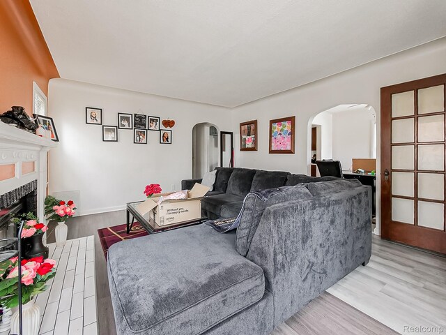15882 Appoline St, Detroit, MI 48227 - living room with arched walkways, wood finished floors, and a tiled fireplace