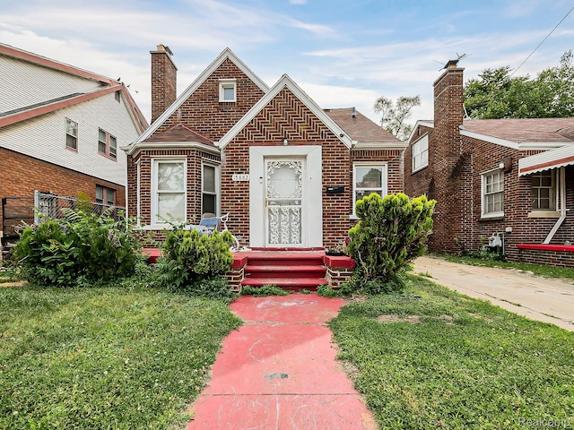 15882 Appoline St, Detroit, MI 48227 - tudor-style house featuring brick siding, a chimney, and a front yard