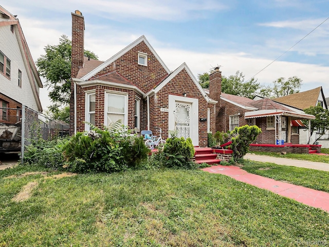 15882 Appoline St, Detroit, MI 48227 - tudor house with brick siding, a chimney, and a front lawn