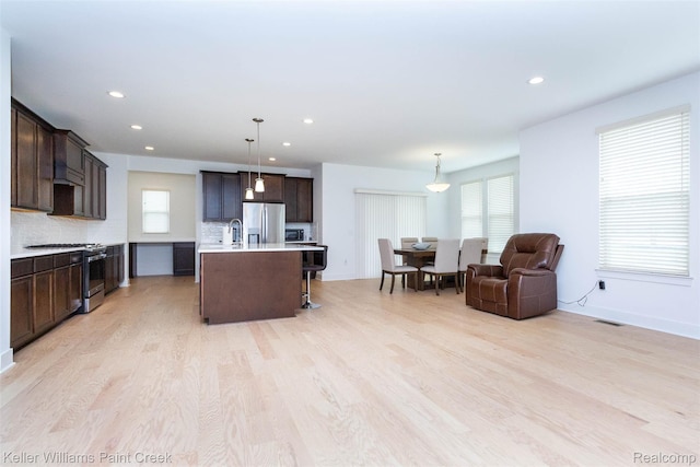24738 Callaway Dr, Macomb, MI 48042 - kitchen featuring stainless steel appliances, dark brown cabinetry, light countertops, light wood-style floors, and healthy amount of natural light
