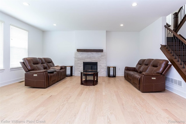 24738 Callaway Dr, Macomb, MI 48042 - living area featuring wood finished floors, stairs, recessed lighting, and a stone fireplace