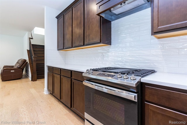 24738 Callaway Dr, Macomb, MI 48042 - kitchen with stainless steel gas range oven, wall chimney exhaust hood, dark brown cabinets, and light countertops