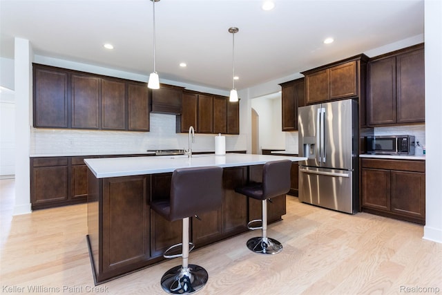 24738 Callaway Dr, Macomb, MI 48042 - kitchen featuring stainless steel appliances, arched walkways, backsplash, light countertops, and light wood-style flooring
