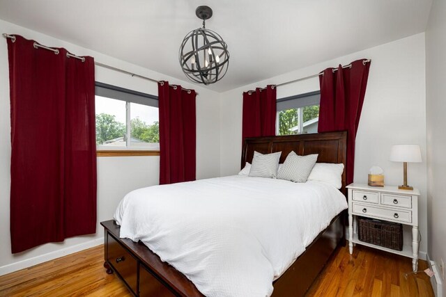 2534 Pamela Ave, Ann Arbor, MI 48103 - bedroom with a chandelier, wood finished floors, and baseboards