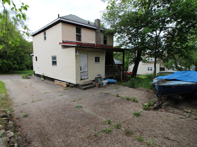 203 W Belmont St, Kalamazoo, MI 49001 - rear view of property with a chimney and driveway