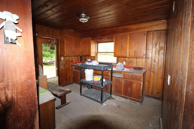 203 W Belmont St, Kalamazoo, MI 49001 - kitchen with brown cabinets, plenty of natural light, wood walls, wooden ceiling, and concrete floors