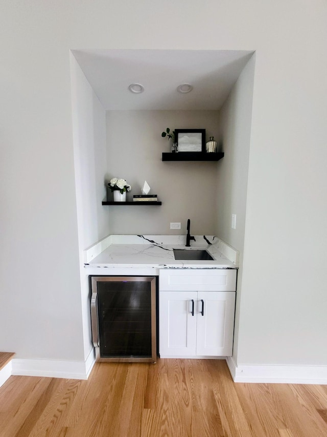 340 N Berrien St, New Buffalo, MI 49117 - bar area with beverage cooler, a sink, light wood-style floors, and baseboards