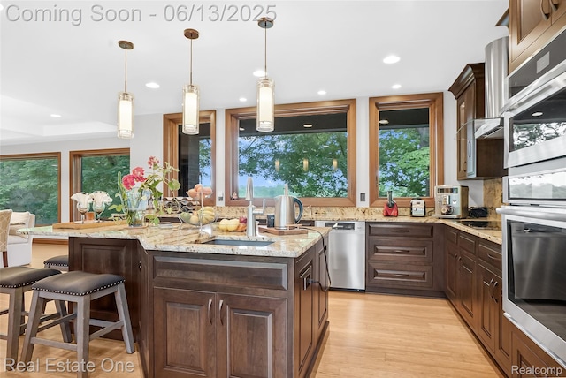 15349 Lakeside St, Plymouth, MI 48170 - kitchen with appliances with stainless steel finishes, a center island, dark brown cabinets, light stone counters, and recessed lighting