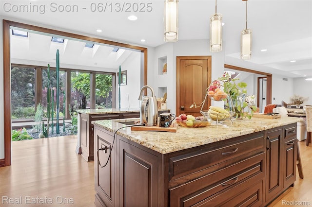 15349 Lakeside St, Plymouth, MI 48170 - kitchen featuring a kitchen island, light wood finished floors, recessed lighting, light stone counters, and open floor plan