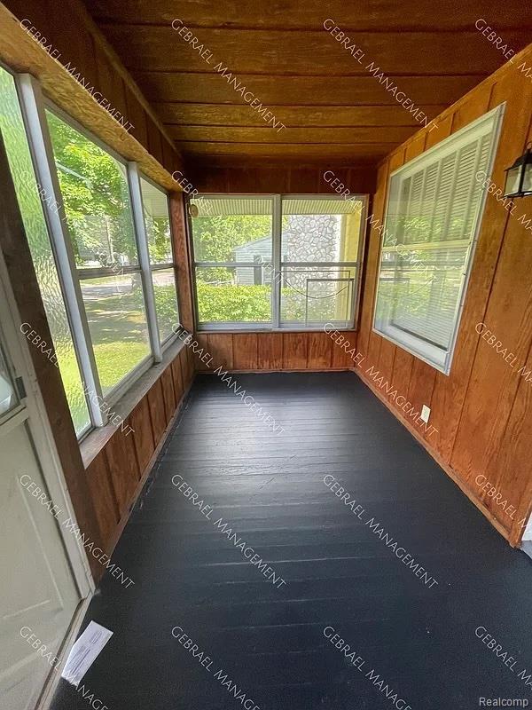 2307 Monteith St, Flint, MI 48504 - unfurnished sunroom with wooden ceiling, wooden walls, and wood finished floors