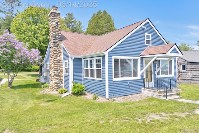 2968 Wolverine Rd, East Tawas, MI 48730 - view of front of property with a chimney, a front yard, and a shingled roof