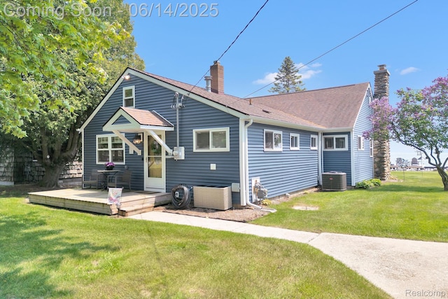 2968 Wolverine Rd, East Tawas, MI 48730 - back of property featuring a chimney, a lawn, and a shingled roof