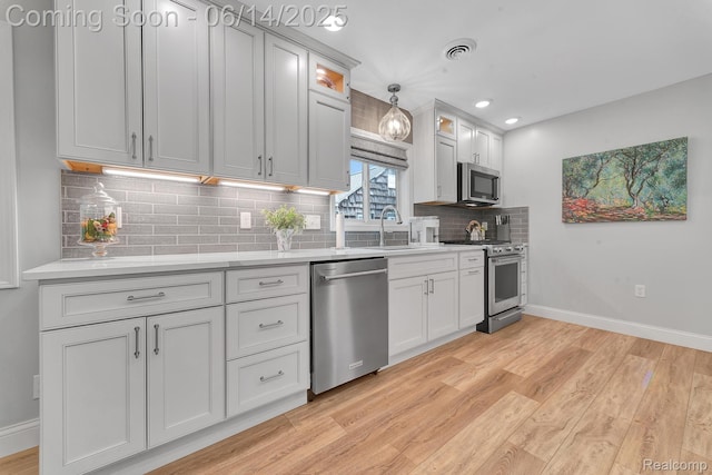 2968 Wolverine Rd, East Tawas, MI 48730 - kitchen with stainless steel appliances, light wood-style floors, backsplash, light countertops, and recessed lighting