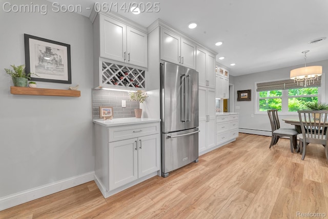 2968 Wolverine Rd, East Tawas, MI 48730 - kitchen with high end refrigerator, a baseboard radiator, light wood finished floors, light countertops, and a chandelier