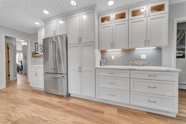 2968 Wolverine Rd, East Tawas, MI 48730 - kitchen with high end fridge, backsplash, light wood-style floors, recessed lighting, and white cabinetry