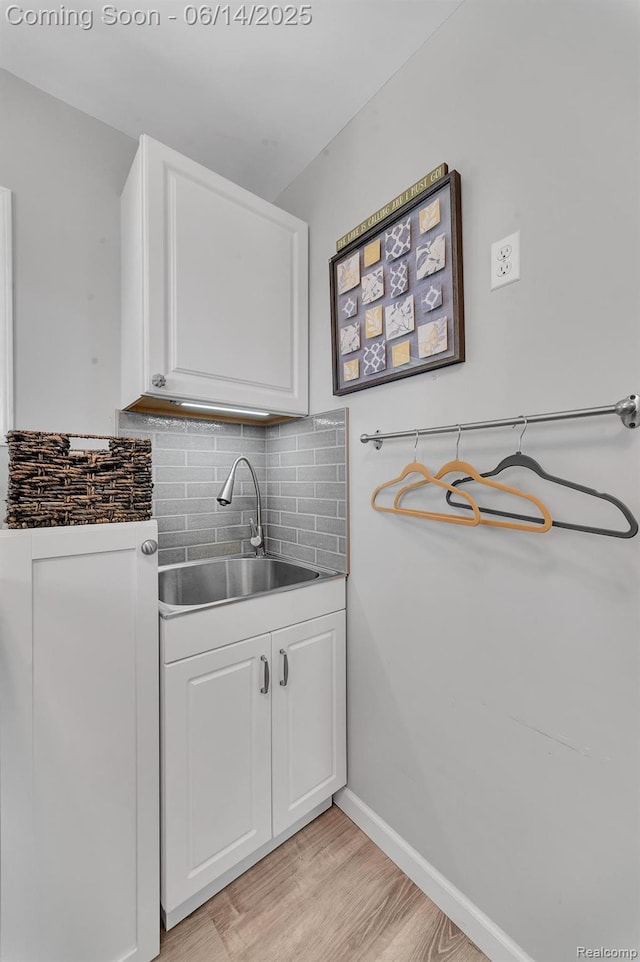 2968 Wolverine Rd, East Tawas, MI 48730 - kitchen with white cabinets, light wood finished floors, and decorative backsplash