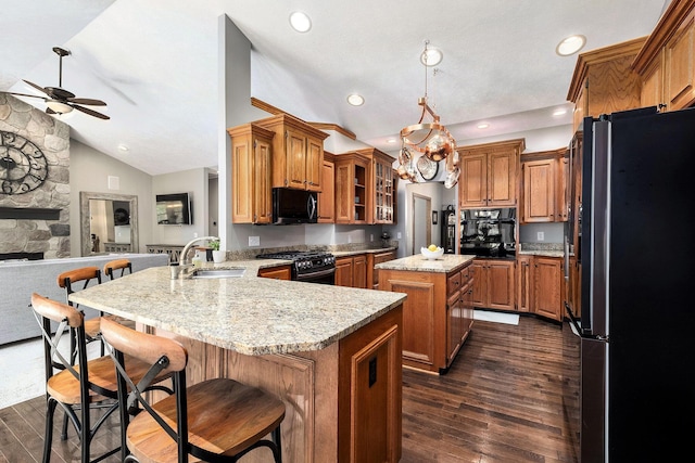 6526 Ada Dr SE, Ada, MI 49301 - kitchen featuring black appliances, a sink, ceiling fan, a peninsula, and brown cabinets