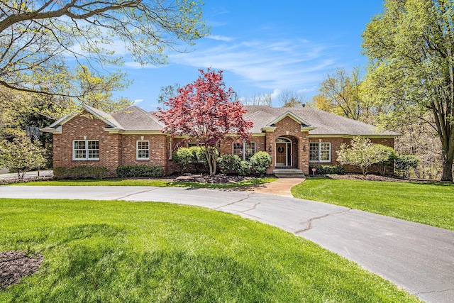 6526 Ada Dr SE, Ada, MI 49301 - view of front of house with brick siding, a shingled roof, and a front yard