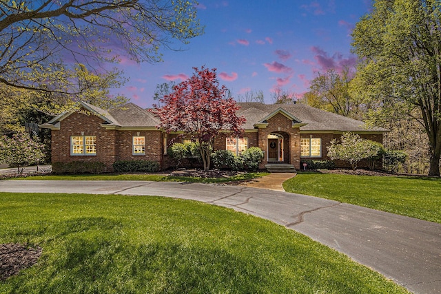 6526 Ada Dr SE, Ada, MI 49301 - view of front of property with brick siding, a front yard, and roof with shingles