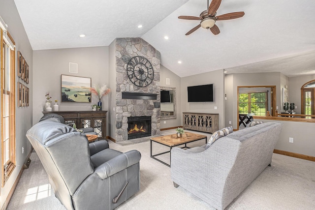 6526 Ada Dr SE, Ada, MI 49301 - living area featuring light carpet, vaulted ceiling, baseboards, a ceiling fan, and a fireplace