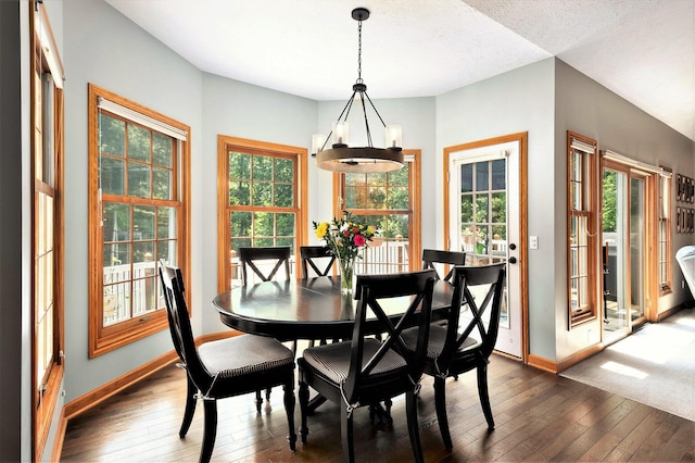 6526 Ada Dr SE, Ada, MI 49301 - dining space with dark wood-style flooring, baseboards, plenty of natural light, and a chandelier