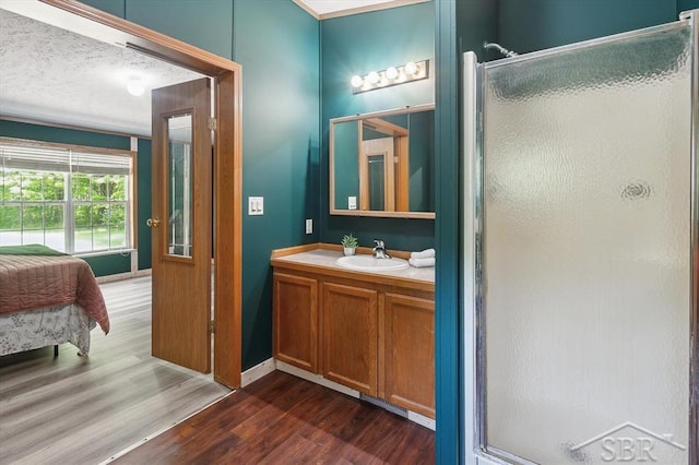 3251 W Dana Rd, Coleman, MI 48618 - ensuite bathroom with wood finished floors, vanity, a stall shower, and baseboards