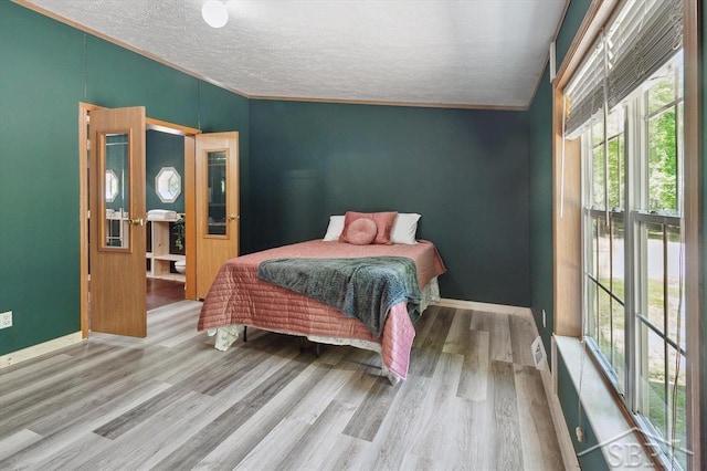 3251 W Dana Rd, Coleman, MI 48618 - bedroom featuring multiple windows, wood finished floors, a textured ceiling, and baseboards