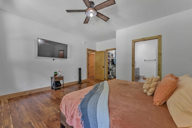 9725 Green Briar Rd, Lake Ann, MI 49650 - bedroom with wood finished floors, a walk in closet, connected bathroom, a ceiling fan, and a closet