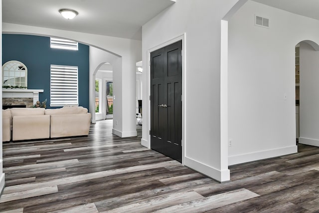 55135 Hanford Ct, Utica, MI 48316 - foyer featuring arched walkways, dark wood-style floors, a fireplace, and baseboards