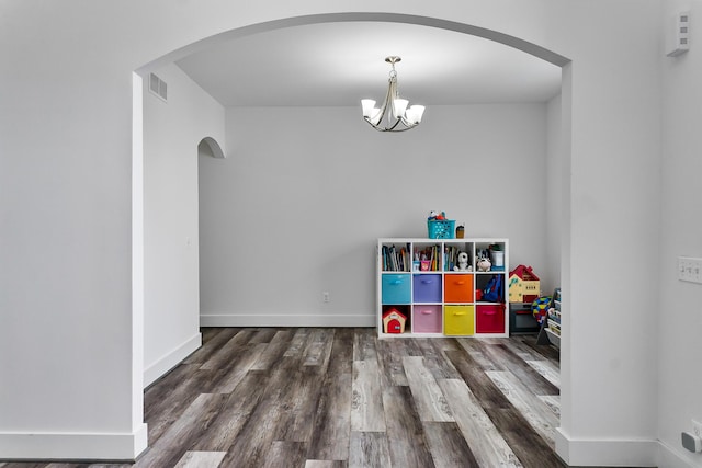 55135 Hanford Ct, Utica, MI 48316 - rec room with arched walkways, a chandelier, wood finished floors, and baseboards