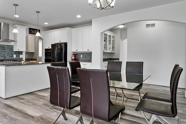 55135 Hanford Ct, Utica, MI 48316 - dining area with light wood-style floors, arched walkways, recessed lighting, and a chandelier