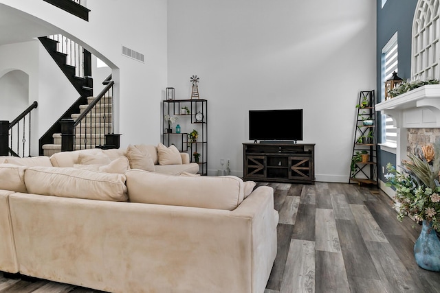 55135 Hanford Ct, Utica, MI 48316 - living area featuring a high ceiling, dark wood-style floors, stairway, arched walkways, and baseboards