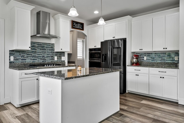 55135 Hanford Ct, Utica, MI 48316 - kitchen with wall chimney range hood, appliances with stainless steel finishes, arched walkways, a kitchen island, and white cabinets