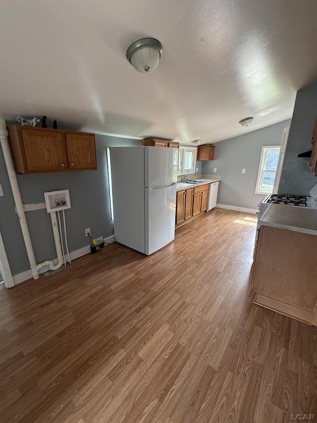 212 W Union St, Morenci, MI 49256 - kitchen with freestanding refrigerator, brown cabinets, dishwasher, wood finished floors, and baseboards