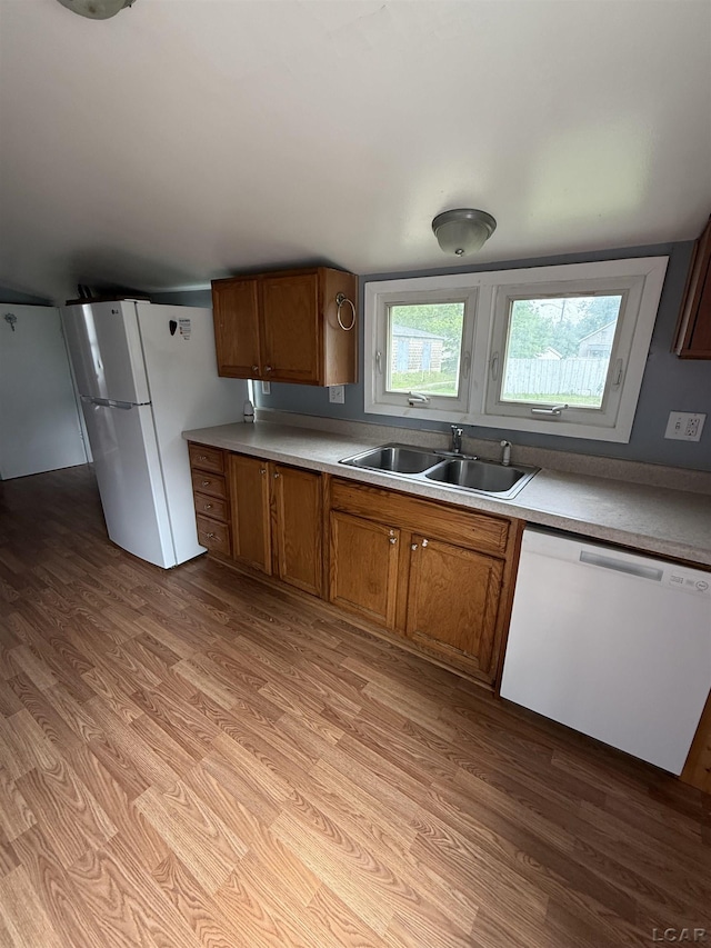 212 W Union St, Morenci, MI 49256 - kitchen featuring dishwashing machine, a sink, light wood-style flooring, freestanding refrigerator, and brown cabinetry