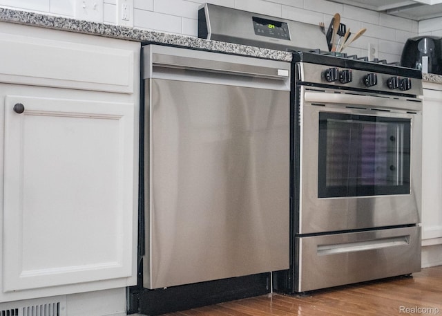 1156 Fairway Dr, Pontiac, MI 48340 - kitchen featuring dishwasher, wood finished floors, white cabinets, and tasteful backsplash