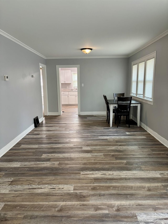 2138 N Clinton St, Saginaw, MI 48602 - unfurnished dining area featuring crown molding, baseboards, and dark wood-type flooring