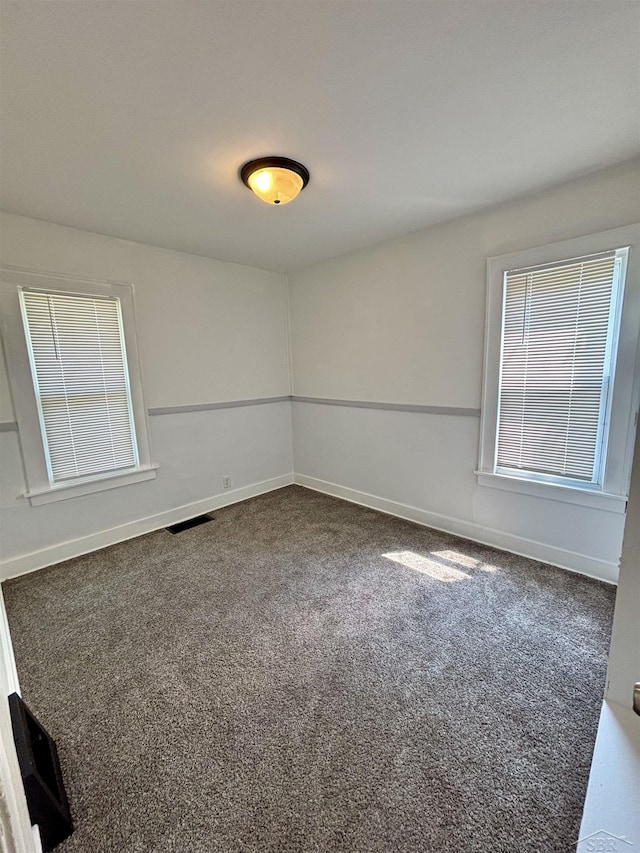 2138 N Clinton St, Saginaw, MI 48602 - unfurnished room with dark carpet and baseboards