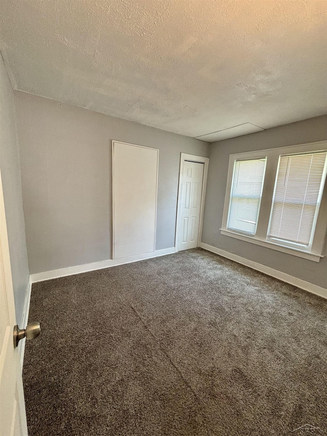 2138 N Clinton St, Saginaw, MI 48602 - unfurnished bedroom with a textured ceiling, carpet, baseboards, and a closet