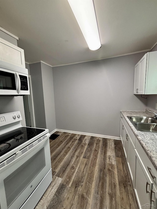 2138 N Clinton St, Saginaw, MI 48602 - kitchen featuring white appliances, a sink, dark wood-style floors, light countertops, and baseboards