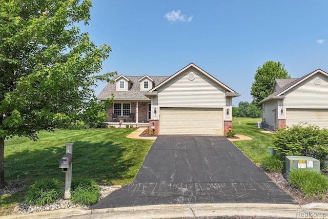 11118 Strathmore Ct, Grand Blanc, MI 48439 - view of front of house with brick siding, a front lawn, and driveway