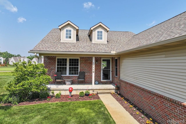 11118 Strathmore Ct, Grand Blanc, MI 48439 - view of exterior entry featuring brick siding, a lawn, and roof with shingles