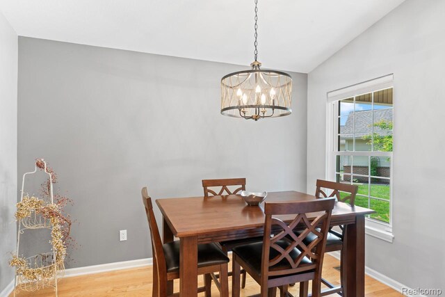11118 Strathmore Ct, Grand Blanc, MI 48439 - dining room with light wood finished floors, lofted ceiling, a chandelier, and baseboards