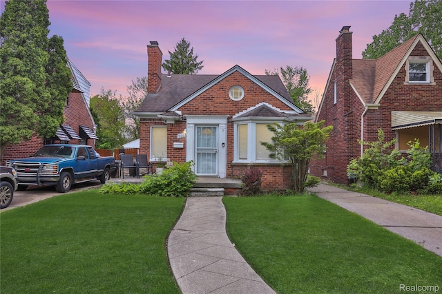 9666 E Outer Dr, Detroit, MI 48213 - view of front of property featuring a front yard, a chimney, brick siding, and a shingled roof