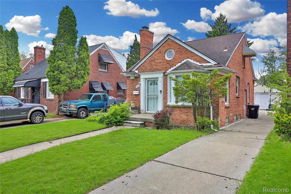 9666 E Outer Dr, Detroit, MI 48213 - bungalow-style home with brick siding, a front yard, and a chimney