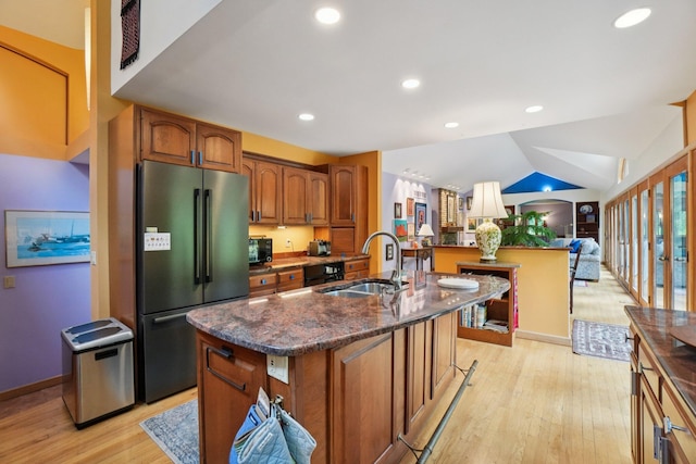 3377 Timberwood Ln, Ann Arbor, MI 48103 - kitchen featuring freestanding refrigerator, light wood-type flooring, a sink, brown cabinetry, and a center island with sink